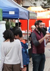 People chatting and looking at plans in a gazebo on a high street